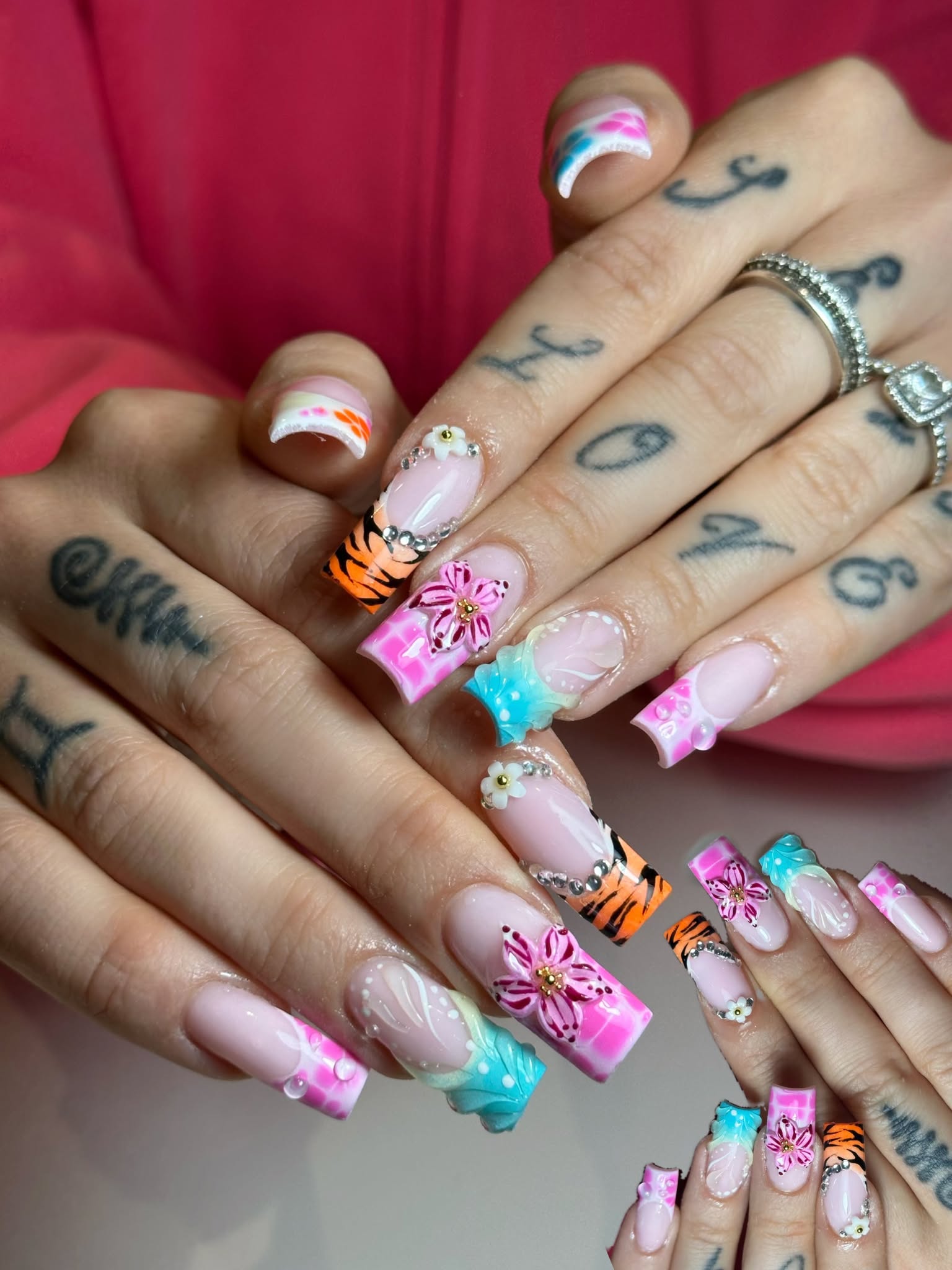Farbiges Nail Art Design mit Blumen und Strass