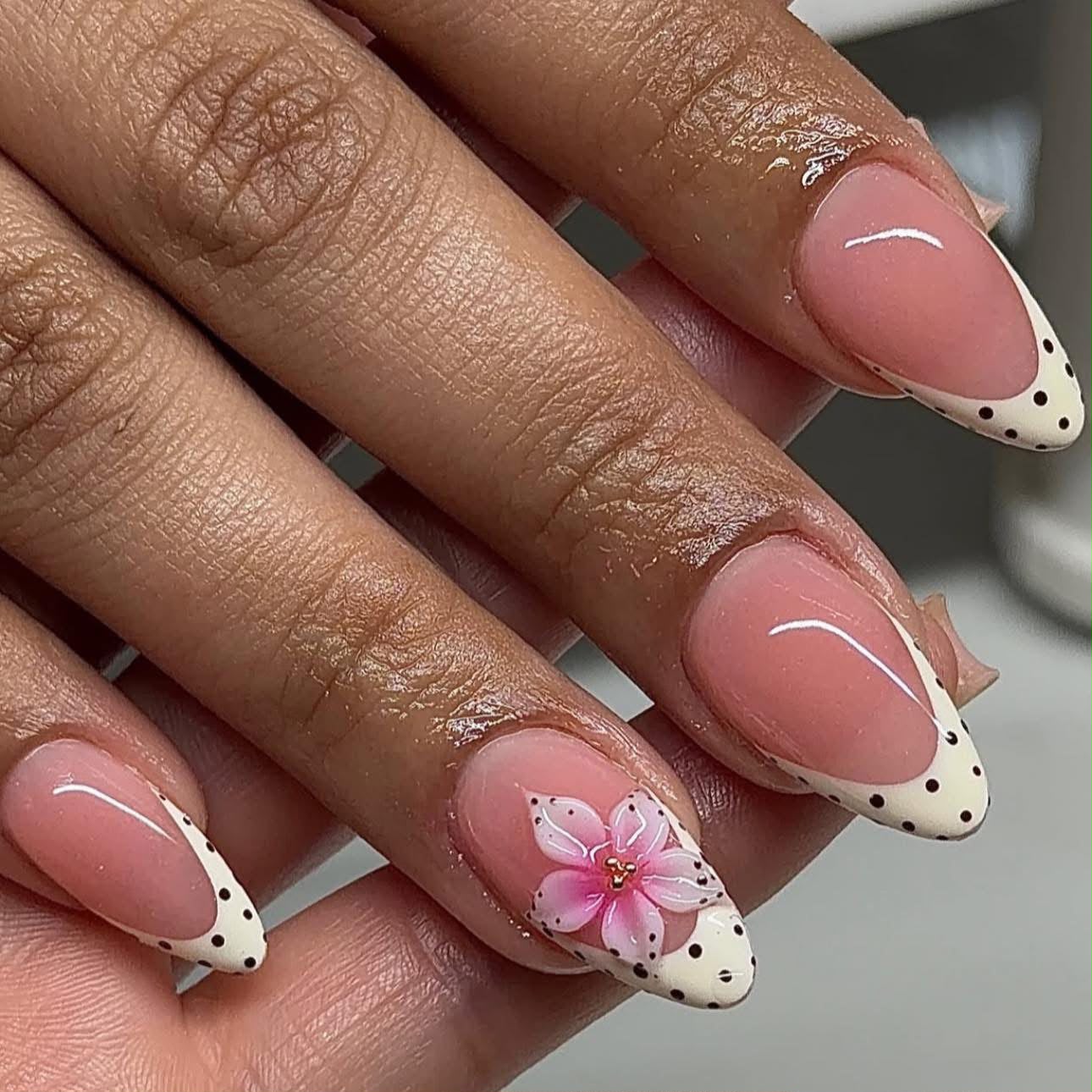 Pink French manicure with dotted tips and floral accent nails