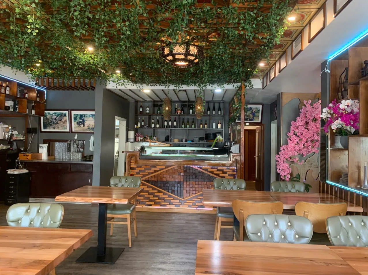 Gastraum des HANA Restaurants in Olsberg mit Holztischen, Polsterstühlen und Sushi-Theke