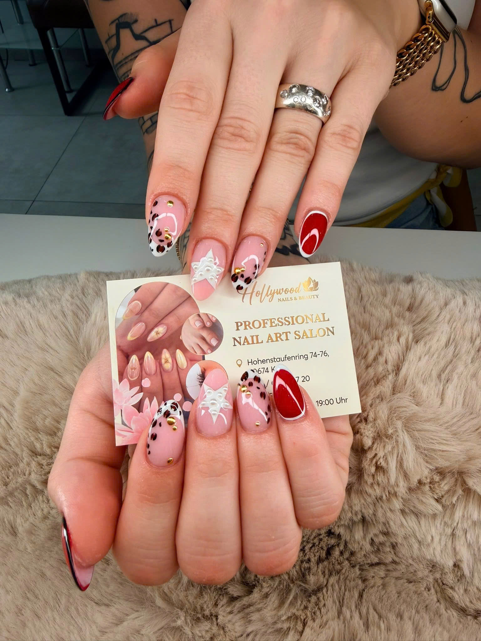 Rosa-rotes Nail Art Design mit feinen Mustern und goldenen Akzenten